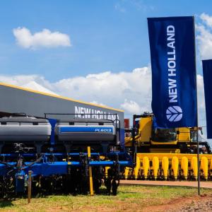 Large New Holland banners next to pieces of agricultural equipment