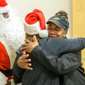 Cusomter hugging Entergy official wearing Santa