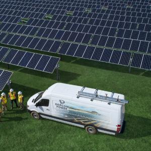 workers near a utility van and solar panels