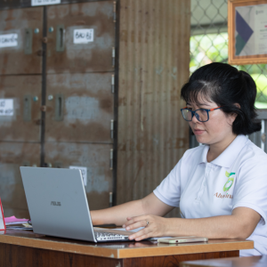 Nguyen Thi Kim Thoa in an office working on a laptop computer