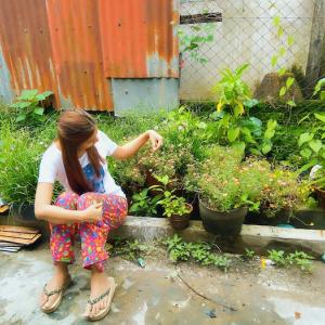Woman tending to flowers and potted plants.