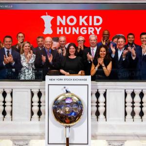 Group ringing the closing bell at No Kid Hungry banner on the front of the New York Stock Exchange