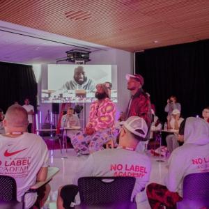 Group of people watching No Label Academy presentation
