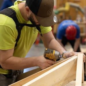 A person joining wood pieces in a workshop.