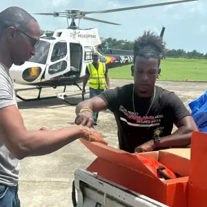 Members of the Office of Eastern Caribbean States, or OECS, load Direct Relief field medic packs and a hurricane preparedness pack into a helicopter in St. Lucia, in preparation for transport to St. Vincent and the Grenadines. (Photo courtesy of OECS)