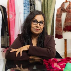 Jyoti Jaiswal sat at a table with their arms folded