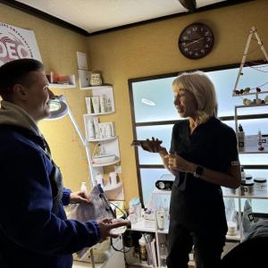 A woman and a man smile and talk in a cosmetics studio.