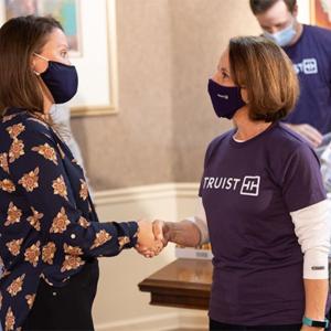Amelia Nickerson, CEO at First Step Staffing shaking hands with a volunteer