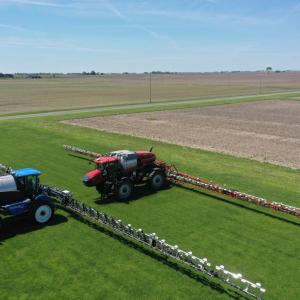 Two tractors spraying fields