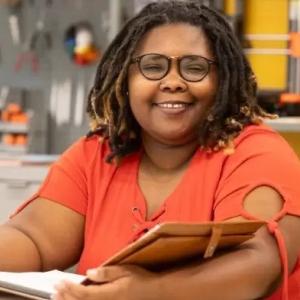 Oni Meeks sat at a desk holding a notebook