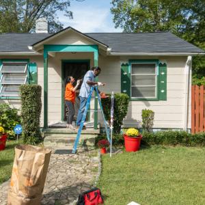 The Home Depot: Operation Surprise. Volunteers are shown painting and cleaning up a house.