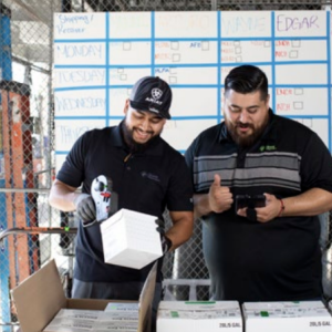 Two workers scanning products out of boxes