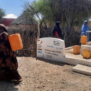 Owliya carries water home from the well. 
