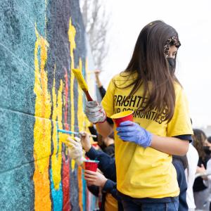 Volunteer working on the mural