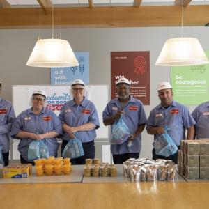 Employees of Post Consumer Brands pack bags of food