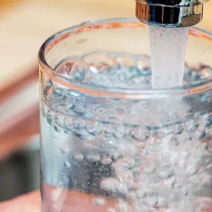 Faucet nearly filled glass of water.