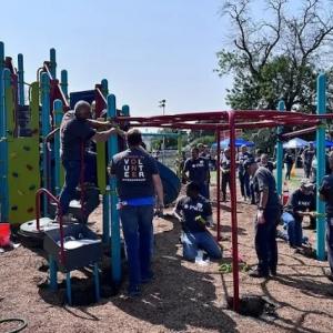 Volunteers working on the jungle jim in the playground.
