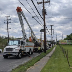 Cherry picker truck preparing to work on electrical wires.