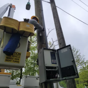 PSEG worker in cherry picker bucket working on electrical poles.
