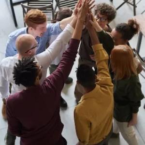 Group of eight people with hands clasped.