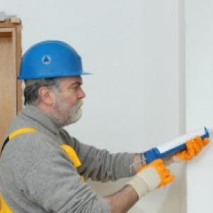 Worker applying caulk to a window.