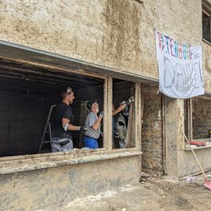 employees rebuilding home destroyed by flooding