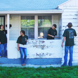 Group of YouthWorks volunteers painting house