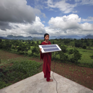 person holding solar panel with beautiful landscape behind