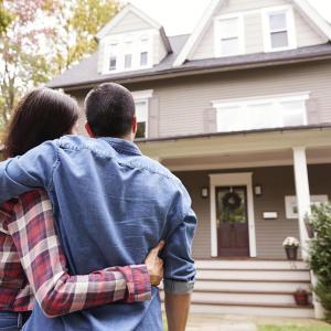 A couple embracing as they look at their new home.