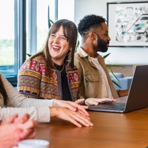 Three GoDaddy team members working together on a laptop.