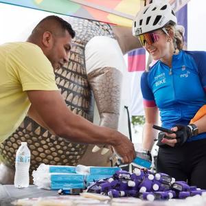 Pedal Power rider shown at a booth with supplies.