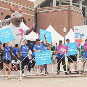 Spectators and Armadillo mascot cheering on the riders.