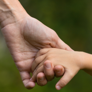 A child holding an adult's hand