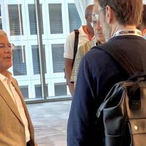 Pedro Pizarro talking with others in an open room with large windows behind them.