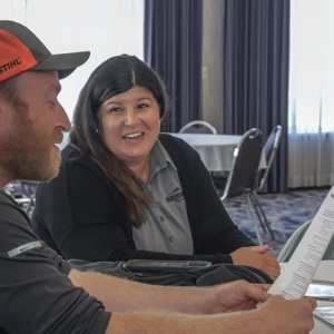 Two people sat at a table while one of them is holding a piece of paper