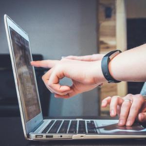 Person touching laptop screen