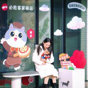 Person sat holding a dog on their lap outside a pet-friendly restaurant 