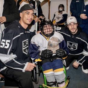 LA Kings players pose with a child from SNAP Flyers Hockey Club.