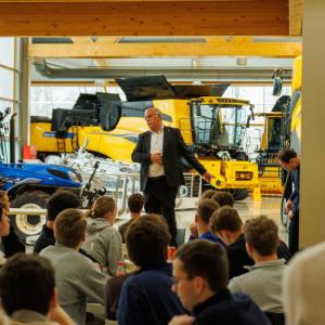 Students listening to a speaker while they await the start of the plant tour