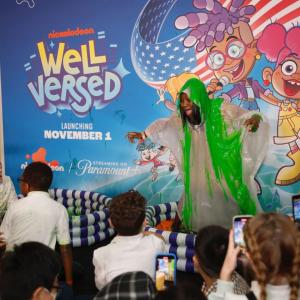 A person stood in a pool in front of an audience of children