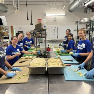 Volunteers cut food in the kitchen