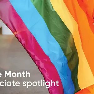 A person holding a rainbow flag. "Pride Month Associate spotlight"