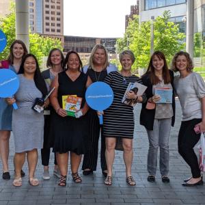 Principal Financial Group employees holding up signs that say Principal Gives Back.