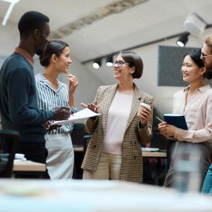 Group of five women and men at work having a discussion.