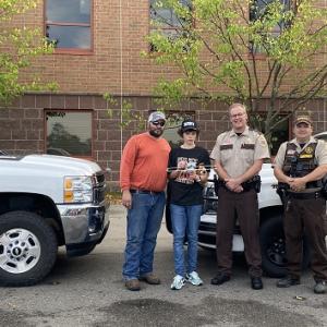 Two people stood next to two Sheriff’s and their cars