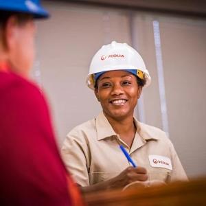 Veolia worker in a hardhat speaking to someone and taking notes