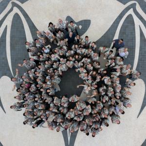Aerial view of a group of people posed in a circle looking up