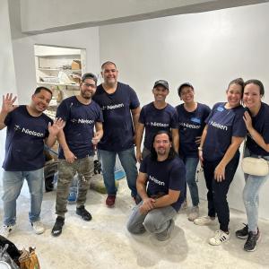 Nielsen volunteers on NGID shown painting a house.