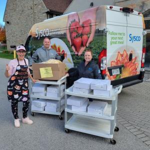 Three people delivering food from a Sysco truck