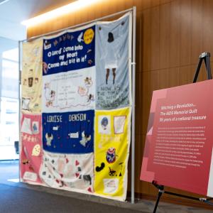 large hanging quilt and poster board to the right explaining it's significance